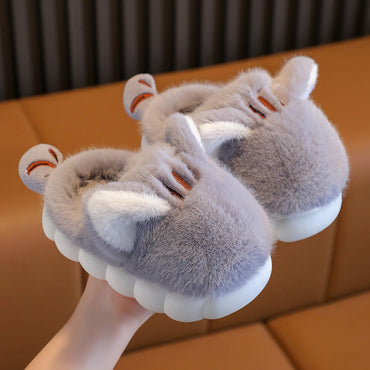 Gray hippo-shaped slippers on a brown surface